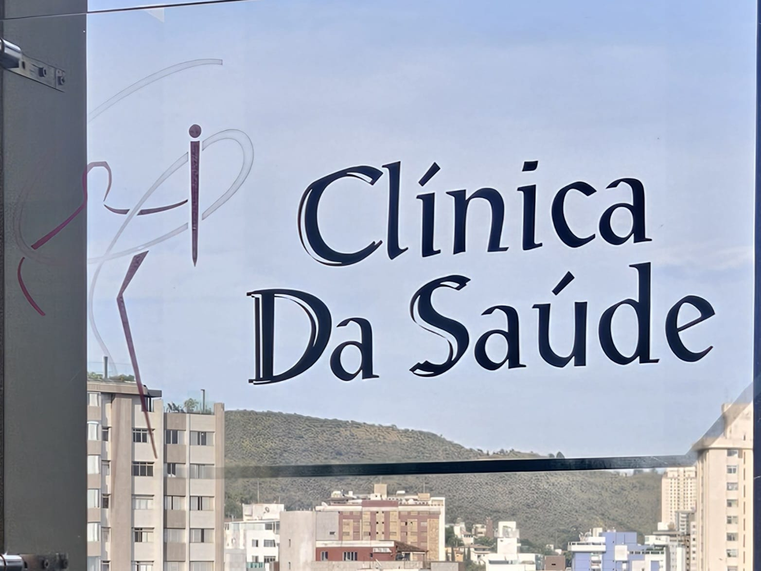 Identidade visual da Clínica da Saúde na porta de vidro
